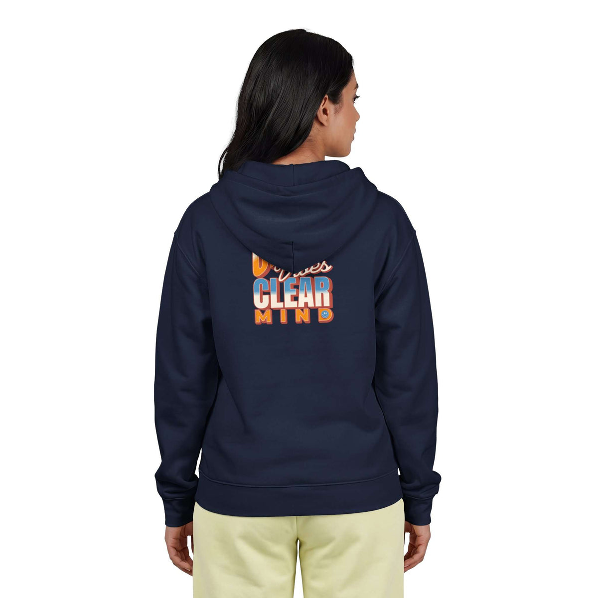A woman viewed from the back wearing a navy blue hoodie with a colorful graphic on the back that reads 'Minnesota CLEAR MIND' in orange, white, and blue, paired with light yellow pants against a plain white background. Shop online Comfortable Chill Vibes Clear Mind Zip Hoodie Casual Wear for soft, everyday comfort, relaxed style, and an effortlessly calm look. Elevate your off-duty wardrobe with the Comfortable Chill Vibes Clear Mind Zip Hoodie—made for warmth, ease, and relaxed moments.