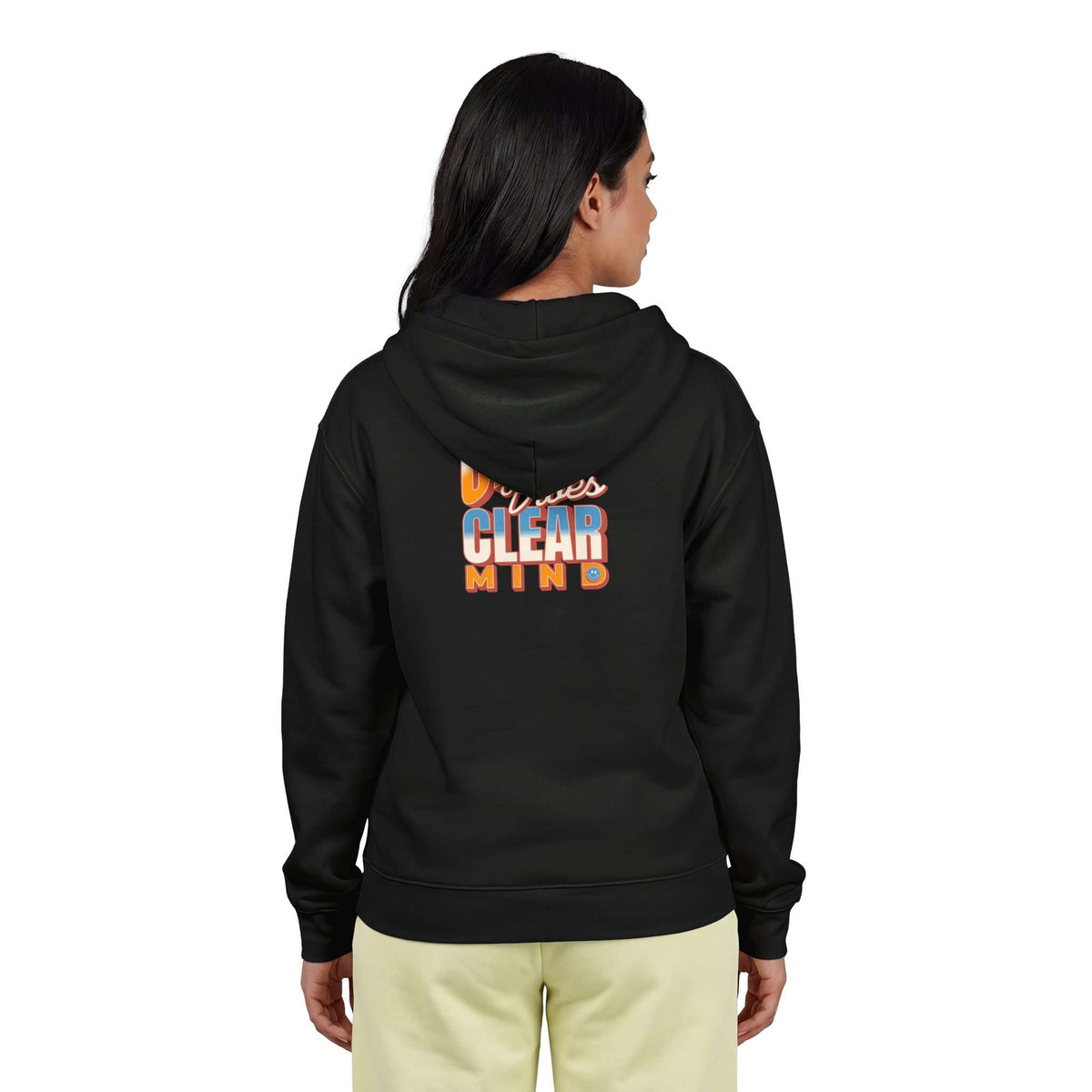 A woman viewed from the back wearing a black hoodie with a colorful graphic on the back that reads 'Minnesota Clear Mind,' paired with light beige pants, against a plain white background. Shop online Comfortable Chill Vibes Clear Mind Zip Hoodie Casual Wear for soft, everyday comfort, relaxed style, and an effortlessly calm look. Elevate your off-duty wardrobe with the Comfortable Chill Vibes Clear Mind Zip Hoodie—made for warmth, ease, and relaxed moments. Buy the Comfortable Chill Vibes Clear Mind Hoodie.