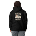 A person shown from the back wearing a black pullover hoodie with a vintage-style mountain graphic and the text 'THE MOUNTAINS ARE CALLING AND I MUST GO' printed on the back. The person is also wearing a dark knit beanie and gray sweatpants against a plain white studio background. Nature Quote Mountains Are Calling Graphic Hoodie Casual Wear Shop the Nature Quote Mountains Are Calling Graphic Hoodie, a cozy statement piece for hikers, campers, and everyday adventure seekers.